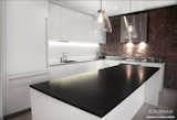 If you're looking for a perfectly black natural stone countertop, Absolute Black granite is your top choice.

In this contemporary kitchen, the Absolute Black granite island countertop provides a clean contrast to the exposed brick and white cabinets.

More info here: http://www.egmcorp.com/granite/black-absolute-india-0