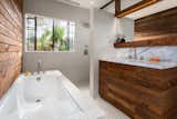 Bathroom with reclaimed wood wall and vanity.  Clerestory above vanity and shower with steel windows allow for more natural light