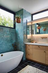 Privacy and natural light:  Bathroom with clerestory windows framing the neighborhood tree canopies beyond.  Blue marble, black Cle cement floor tiles, white oak cabinetry and white mosaic tile backsplash are complimented with French Bronze plumbing fixtures from Rohl.