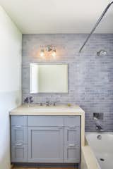 Bath Room, Wall Lighting, Ceramic Tile Wall, Light Hardwood Floor, One Piece Toilet, Ceiling Lighting, Undermount Tub, Engineered Quartz Counter, Undermount Sink, Subway Tile Wall, Open Shower, and Accent Lighting Guest Bath  Photo 17 of 18 in Sunset Hills Residence by Hsu McCullough
