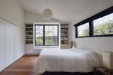 Vaulted ceiling with built-in bookshelves creating a window seat reading nook overlooking the backyard under the pear tree beyond. Smoked oak floor by Shengaris. A single Noguchi pendant with mismatched family heirloom bedside reading lamps offer a simple balance to the natural light from the yards. The cabinetry is highlighted by glass hardware knobs - an understated design highlight for us.