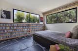 Sleep in the tree canopy.  Simple, built-in wood shelves hold a compact disc collection that in turn becomes a colorful texture 