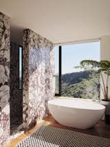 Tub with an uninterrupted private view via the pocketing window as you hover above Fossil Ridge. Or step into the Calacatta Viola-clad wet room shower with a vertical slot window framing the San Fernando Valley floor below. 