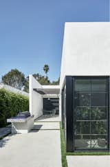 Side yard patio with grill and outdoor dining with pass through windows from kitchen (at right)