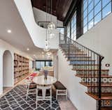 Stair, with riser tiles from Mexico, takes ones to the reading room mezzanine above with dining room open to kitchen, living room and yard beyond