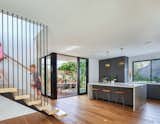Centrally located stair cascades into the kitchen which is open to a covered outdoor dining deck and backyard 