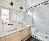 Bathroom with hexagonal cement tile floor, white oak vanity and marble tile walls