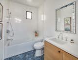 Kid's Bathroom with decorative mirror, white tiles and cement tile floor