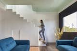 The sawtooth form of the staircase guardrail is utilized a number of areas of the house. A series of south facing windows at the top of stair offer beautiful natural light from above. The cove ceiling is created with a crown moulding detail and painted a light sea-foam color while the media cabinets and wall are painted black to obscure the television. A small door opens under the stair with another door off the child's bedroom beyond for a "secret" play area