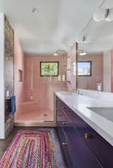 The primary bathroom is playful and colorful with a window framing the mature podocarpus tree