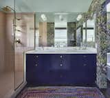 Open to the bedroom, the primary bathroom is playful and colorful featuring a Cole & Son wallpaper