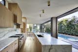 Kitchen opens to swimming pool, deck patio with oak tree and Living Room beyond