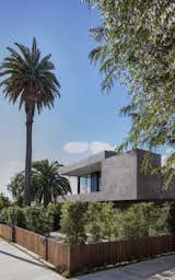 Front facade from sidewalk (North). Stacked rectangular forms and controlled wood and stucco material palette disguises a very long (140 ft.) house that gently steps with the descending slope of the back and side yards. 