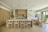 Kitchen with dining room and access to rear yard patio. White oak throughout paired with Taj Mahal stone slabs and a Noguchi for Herman Miller pendant