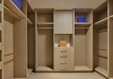 Walk-in closet of the primary suite is lit naturally with a diffused skylight