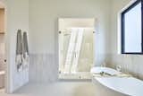 Primary bathroom with Zia Tiles including a tiled wainscot, polished nickel plumbing fixtures, vaulted ceiling, shower with skylight and separate toilet room