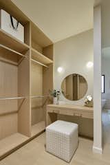 Makeup vanity with Artemide wall sconces within the walk-in closet of the primary suite. Space is lit naturally with a diffused skylight