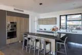 The kitchen is discovered to the left as we walk through.