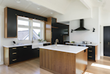 The custom walnut and black cabinets are more dramatic when paired with white walls and countertops