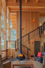 Coffee Tables, Wall Lighting, Light Hardwood Floor, Wood Burning Fireplace, Sofa, Staircase, Metal Railing, and Wood Tread  Photo 4 of 4 in Ferris Cabin by Patano Studio Architecure