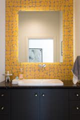 This bright bathroom features Rox Solar yellow ceramic tile by Modwalls Rex Ray Studio, which provides a pop of color, a bit of texture, and a dose of fun.