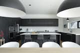 Black laminate kitchen cabinets and white quartz counters.