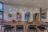 A custom Danish dining room table and elegant light fixtures help define the formal dining room just off the main living and kitchen space.