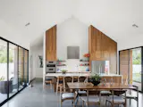 Kitchen cabinets extend to the vaulted ceiling. A subtle patterned 3d tile on the main cooking wall extends to the ceiling as well. The hall beyond the kitchen is lined with high gloss white cabinets that provide additional storage, pantry space and a hidden coffee and toaster bar.