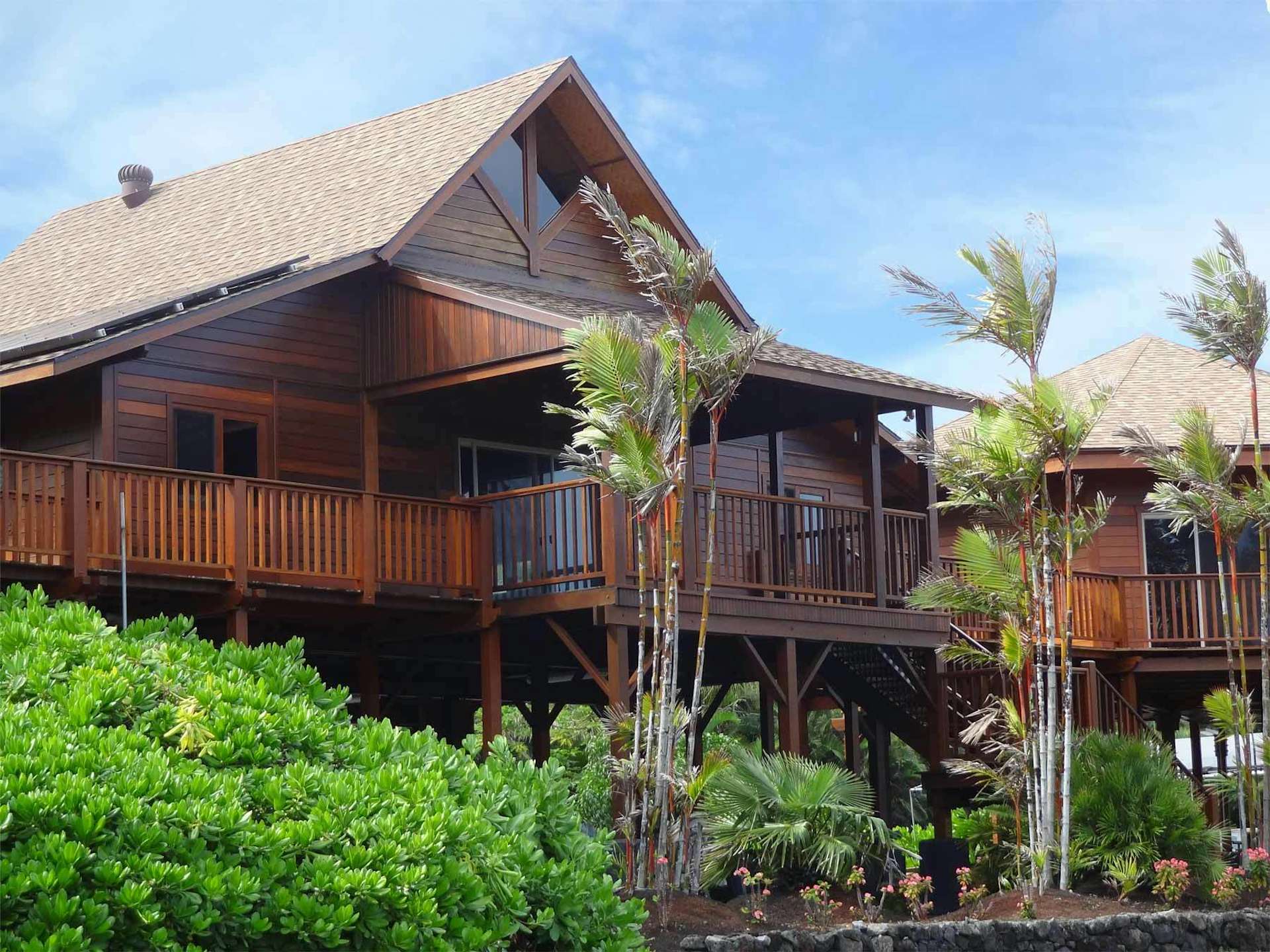 Kapoho by Teak Bali Hardwood Homes is comprised of three structures that are connected by a large wrap-around deck. The walls of the Hawaii prefab home are finished in mango wood.