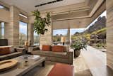A pocketing glass door disappears into stone massing and seamlessly merges indoor with outdoor living spaces. With Pinnacle Peak (right) and city lights beyond, this project is the definition of beautiful views.