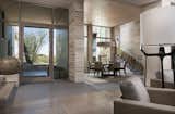A glass entry door welcomes visitors. A cozy dining room is surrounded by stone walls while a stunningly detailed stair leads to guest quarters.