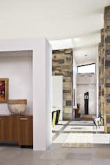 The stone columns featured in this hallway are shared with an entry courtyard. The owner's art collection adds subtle interest to the space.