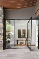 A stunningly simple pivot glass door welcomes guests to this Collector's Paradise in north Scottsdale.