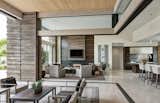 Exterior living spaces extend into the home when perpendicular glass doors disappear into columns of stacked Cantera Negra stone.  