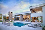 Outdoor living and dining rooms share a double-sided fireplace while swimming beckons from the pool.  