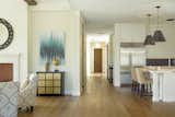 A gallery bathed in light connects entry, office, and living spaces. 