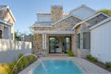 The Sycamore Plan C has picture-perfect outdoor living enhanced by stone, gables, and cool blue water -- a farmhouse oasis in the desert. 