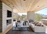 Continuation of stair stepped limestone to the outdoor fireplace blurs the lines between indoor and outdoor spaces using seamless transitions.  

Transition to outdoor space is eased by continuity of materials including Hemlock wood ceilings and stair-stepped limestone. 

Nestled near the base of Pinnacle Peak, this striking dwelling, which channels a Wrightian vibe, provides its owners spectacular indoor-outdoor living. 