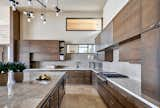 A custom chandelier adds a sculptural element to the crips lines of the kitchen.