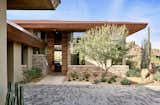 Exterior, Stucco Siding Material, Metal Roof Material, Tile Roof Material, Wood Siding Material, Flat RoofLine, Glass Siding Material, House Building Type, and Stone Siding Material A custom door offers a vertical peek at Pinnacle Peak beyond.   Photo 1 of 16 in Desert Prairie by Drewett Works