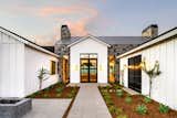 The fresh, modern vibe of this Phoenix farmhouse speaks to neighborhood's citrus grove history. Sonoma Charcoal Limestone and Musket Grey metal roof provide texture and sharp contrast to the painted white siding.  