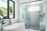 Bianco (walls) and Bardiglio Grey honed marble (shower floor) create a textural and subtle cove for the wet areas of the master bath. A Kohler tub and Brizo fixtures complete the sophisticated and clean look.  