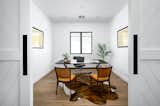 The office is made private by the repeated theme of custom rolling barn doors.