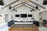 A clean, lofty space for fun, natural materials abound including reclaimed barn wood built-ins, a white-washed distressed wood floor, and wood beams.