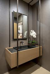 A unique custom designed floating vanity  reinforces the clean lines from the architecture and utilizes metal hoops to suspend the sink.