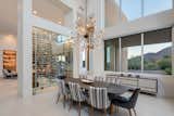 A glass-walled wine room separates the living and dining areas. 

Chairs and a buffet with Danish Modern styling bring a '50s vibe to the great room's dining area. 