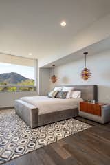 A custom-made wood and chenille bed frame with attached side tables are the centerpiece of this master suite. 

Windows in the master suite perfectly frame views of Camelback Mountain. 
