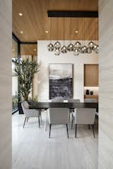 Ownby Designs commissioned a custom table from Peter Thomas Designs featuring a wood-slab top on acrylic legs, creating the illusion that it's floating. A pendant of glass balls from Hinkley Lighting is a key focal point. 

A Douglas fir ceiling, along with limestone floors and walls, creates a visually calm interior.

Project Details // Now and Zen
Renovation, Paradise Valley, Arizona
Architecture: Drewett Works
Builder: Brimley Development
Interior Designer: Ownby Design
Photographer: Dino Tonn
Millwork: Rysso Peters
Limestone (Demitasse) flooring and walls: Solstice Stone
Windows (Arcadia): Elevation Window & Door
Table: Peter Thomas Designs
Pendants: Hinkley Lighting

https://www.drewettworks.com/now-and-zen/