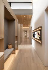 Not many mudrooms have the ambience of an art gallery, but this cleverly designed area has white oak cubbies and cabinets for storage and a custom wall frame at right that features rotating artwork. The flooring is European oak.

Project Details // Now and Zen
Renovation, Paradise Valley, Arizona
Architecture: Drewett Works
Builder: Brimley Development
Interior Designer: Ownby Design
Photographer: Dino Tonn
Millwork: Rysso Peters
Limestone (Demitasse) flooring and walls: Solstice Stone
Windows (Arcadia): Elevation Window & Door

https://www.drewettworks.com/now-and-zen/