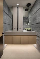 With its cavernous ambiance, the basement powder room is a mix of earthy hues and unexpected elements. An underlit floating vanity with stained oak cabinetry, vertical faucet wall, and textured blue stone tilework combine in an award-winning design.

A contemporary black pendant light by Vibia illuminates a quartz countertop from Cesarstone. Oversize floor tiles from Villagio complement the company's wall tiles.

The Village at Seven Desert Mountain—Scottsdale
Architecture: Drewett Works
Builder: Cullum Homes
Interiors: Ownby Design
Landscape: Greey | Pickett
Photographer: Dino Tonn

https://www.drewettworks.com/the-model-home-at-village-at-seven-desert-mountain/
